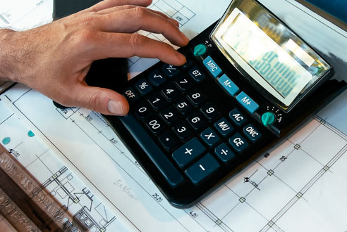 Larkin Hathaway team member reviewing blueprints and calculating costs for an HVAC project